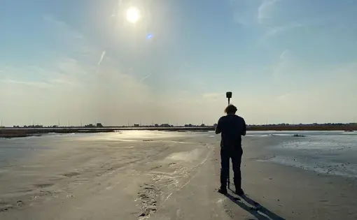 A scientist from the Army Corps of Engineers measures the elevation of newly placed dredge material on Gull Island, located within the Intracoastal Waterway off Stone Harbor in Cape May County. Image courtesy of the Wetlands Institute.