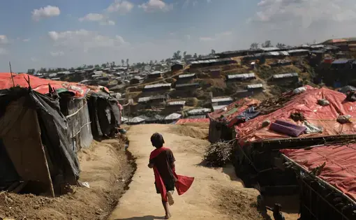 In this November 19 photo, a Rohingya Muslim child runs on a mud track between tents at Kutupalong refugee camp in Bangladesh. Image by Maye-e Wong. Bangladesh, 2017. 