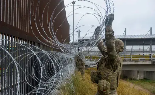 U.S. Army soldiers with the 889th Engineering Support Company, lay concertina wire along the Gateway International Bridge in Brownsville. Image courtesy of U.S. Air Force, via Reuters. United States, 2018.