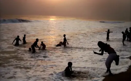 From the Everyday Africa Instagram (@everydayafrica): "A woman photographs children playing in the ocean in Grand-Bassam, Ivory Coast on Sept. 12, 2013. Just outside of Abidjan, Ivory Coast's largest city, Grand-Bassam is a popular weekend destination for thousands of Ivorians." Image by Peter DiCampo. Ivory Coast, 2013.