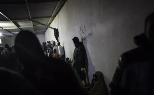 FILE - In this Nov. 29, 2013, file photo African migrants wait in a barrack at a detention center for illegal migrants in Abu Salim district on the outskirts of Tripoli, Libya. The United Nations opened its "Gathering and Departure Facility" in Libya a year ago as an alternative to imprisonment in such places as Abu Salim. The U.N. facility was intended to be a last, safe stop for migrants before they were resettled in other countries. Now, just a year later, it looks increasingly like the notorious Libyan…