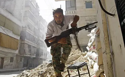 A Free Syrian Army fighter takes cover during clashes with Syrian Army in the Salaheddine neighbourhood of central Aleppo August 7, 2012. REUTERS/Goran Tomasevic courtesty Creative Commons. Syria, 2016.