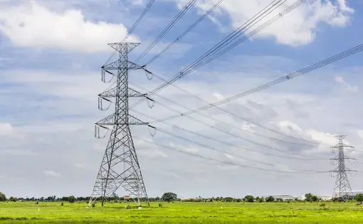 Hi-voltage electrical pylons against blue sky. Image by Happypix / Shutterstock.
