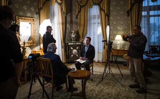 A PBS NewsHour interview with Vadim Pokrovsky, head of the Russia’s Federal AIDS Center, at the Metropol Hotel in Moscow illustrates that TV, unlike print, requires substantial equipment and crew. Image by Misha Friedman. Russia, 2017.