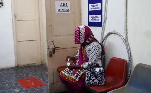 An HIV-positive woman peels the labels off her medication at the government ART center so that her family members will not discover her HIV status. Image by Aditi Kantipuly. India, 2016.