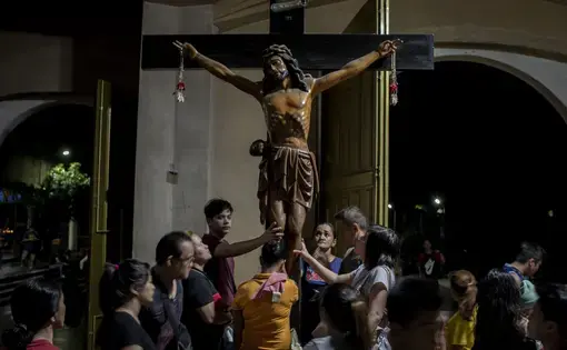 Parishioners touch the crucifix after an evening service at Baclaran Church in Manila. Image by Eloisa Lopez. Philippines, 2018.