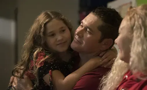 Rayma Flores spends a happy moment with her father, Ramon, and mother, Enedis, after Thanksgiving dinner. Rayma and her siblings can only see their father on the weekends in Tijuana, Mexico, because he was deported from the United States in August 2017. Image by Amanda Cowan. Mexico, 2019.