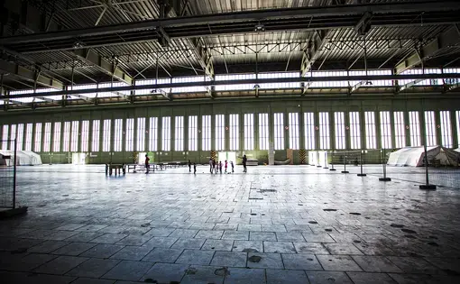 Children play in a hanger in Tempelhof airport, once a Nazi hanger and now home to over 2000 refugees. Image by Emily Kassie. Germany, 2016.
