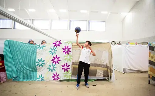 Abdullah, 12, lives in a crowded converted gym outside Berlin that houses refugees. Image by Emily Kassie. Germany, 2016.