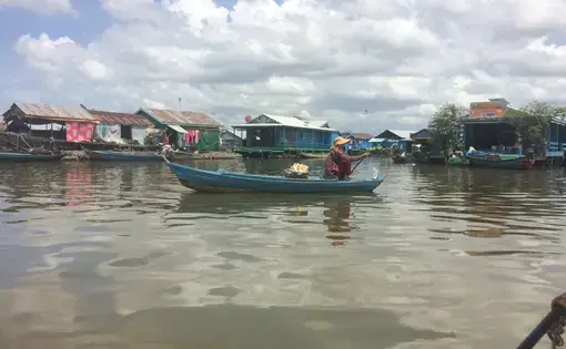 An ethnic Vientamese food&nbsp;vendor paddles through a floating village on Tonlé Sap Lake. Image by Ben Mauk. Cambodia, 2017.