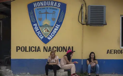 Family members wait outside the Ramon Villeda International Airport in La Lima, Honduras on Nov. 29, 2019, for the arrival of their relatives who were deported from the United States. Immigration apprehensions along the U.S.-Mexico border have plunged by more than 70 percent in the past six months, down sharply from at least 132,000 in May. Image by Moises Castillo/ AP Photo. Honduras, 2019.