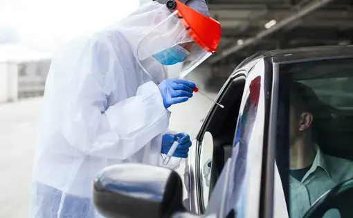 A medical worker administers a COVID-19 swab at a mobile testing center. In the fall of 2020, Novavax launched a&nbsp;phase III COVID-19 vaccine trial in the United Kingdom. Image by&nbsp;Cryptographer / Shutterstock. United Kingdom, 2020.