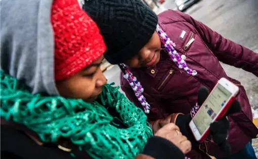 Nicole Glaze owner of Great Start Day Care in North Braddock, left, and Kee’Miyah West, 8, look at Kee'Miyah's Christmas toy wishlist. Image by Michael M. Santiago/Post-Gazette. United States, 2019.