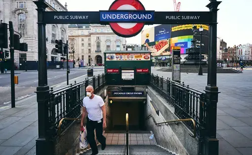 A person wearing a mask exits the London underground. Photo by&nbsp;Matteo Roma / Shutterstock. United Kingdom, 2020.