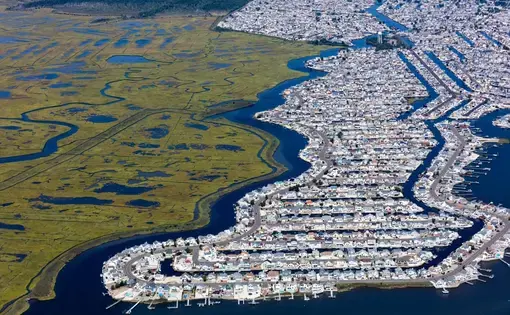 The subdivision Beach Haven West was carved out of a New Jersey salt marsh beginning in 1945. The passage of the state Wetlands Protection Act of 1970 prevented additional loss of wetlands in New Jersey. Scientists with Rutgers University in New Jersey forecast a rise of sea level along the state’s shoreline of as much as 106 centimeters by 2100. That would inundate a large percentage of this community of almost 4,000 people. Image by Alex MacLean. United States, 2019. The subdivision Beach Haven West was carved out of a New Jersey salt marsh beginning in 1945. The passage of the state Wetlands Protection Act of 1970 prevented additional loss of wetlands in New Jersey. Scientists with Rutgers University in New Jersey forecast a rise of sea level along the state’s shoreline of as much as 106 centimeters by 2100. That would inundate a large percentage of this community of almost 4,000 people. Image by Alex MacLean. United States, 2019.