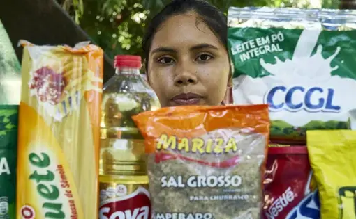 Joane with products from her village wrapped in plastic. Image by Pablo Albarenga. Brazil, 2019.