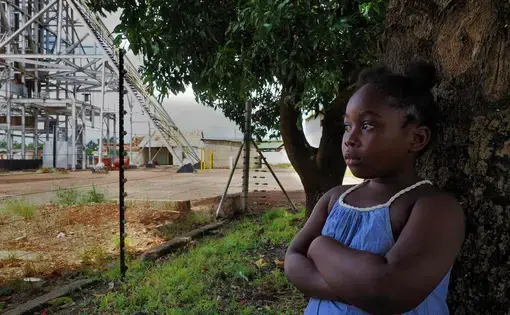 Lead poisoning victim Royce Sakaloa, 6, plays in her backyard less than 50m from the entrance to the former mine. Image by Larry C. Price. Zambia, 2017.