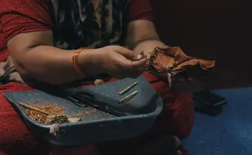 A beedi worker in Karnataka explaining why fingerprints fade during the process of handling tobacco while rolling beedis. Image by Pallavi Puri. India, 2019.