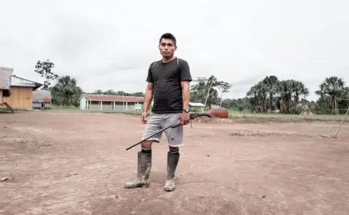 Man standing with gun. Image by Marcio Pimenta. Peru, 2019.