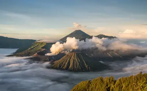 Mount Bromo with smoke, with Mount Batok in the foreground, and Mount Kursi and Mount Gunung Semeru in the background, volcano, in Bromo Tengger Semeru National Park. Image courtesy of Shutterstrock. Indonesia, date unknown.