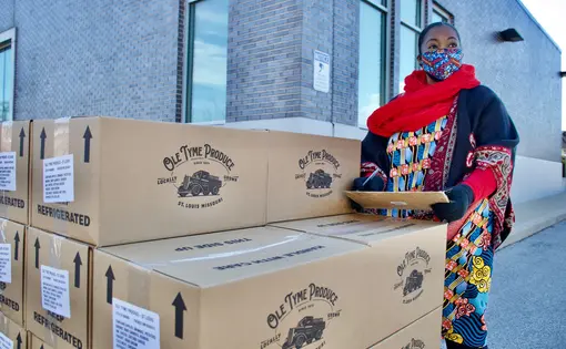 Kim Daniel keeps track of food being distributed to residents during a food drive at the Flance Early Learning Center. Image by Wiley Price/St. Louis American. United States.