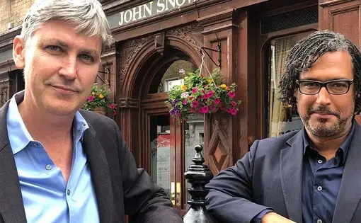 Steven Johnson and David Olusoga stand together on a city street.