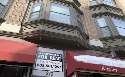 A sign advertises apartments to rent above a business in Madison, Wisconsin.