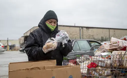 A person packs boxes with bread products.
