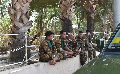 Military soldiers from the convoy accompanying the press tour waiting on the side of the road.