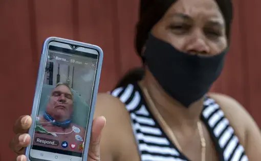 The widow of a meatpacking plant employee shows a photo of her husband.