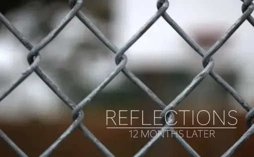 A chain link fence with the title "Reflections" on screen.
