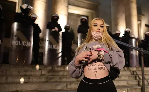 A person exposes their stomach in front of law enforcement during an abortion rights demonstration in Poland.