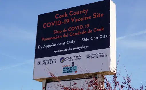 A sign for a Cook County COVID-19 mass vaccination site in suburban Chicago. The sign is bilingual in English and Spanish.