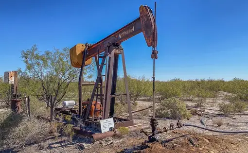 Photo of oil pump jack fracking crude extraction machine.