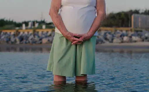Jean Hooper posed for a portrait in the Pamlico Sound at the Salvo Community Cemetery in 2018.