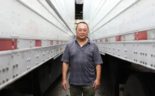 Truck driver Don Wong walks past parked trailers.
