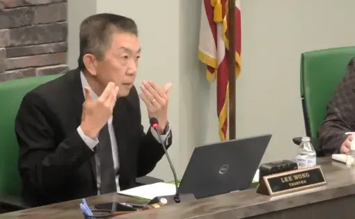 Lee Wong speaks at a government meeting.