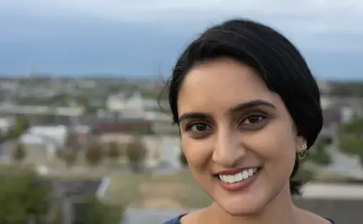 A portrait of Divya Mishra smiling.