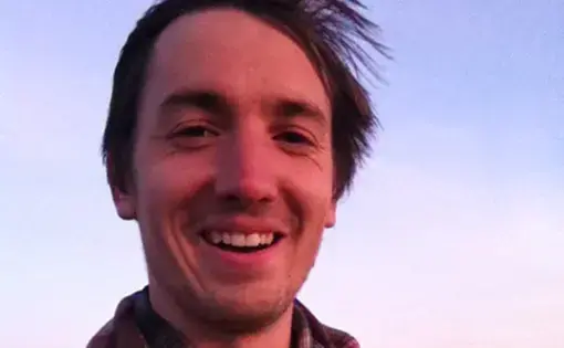 Photo of Nate Hegyi in plaid shirt at sunset