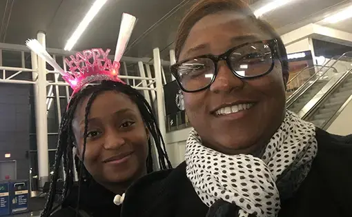 A photo of Saichelle McNeill and her daughter J’Nai. J'Nai wears a "Happy New Year" headband.