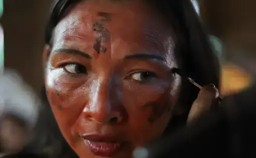 woman applying red paint as part of Indigenous tradition