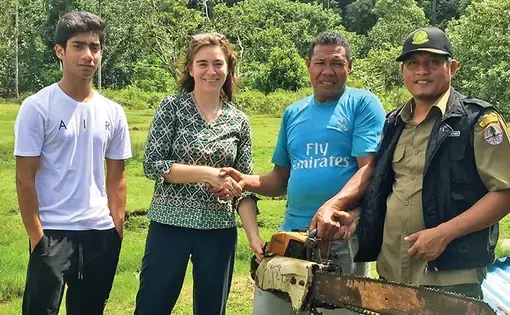 BERHENTI MEMBALAK: Kinari Webb (dua dari kiri) menerima gergaji mesin yang biasa digunakan menebang pohon. (DOKUMENTASI KLINIK ASRI)