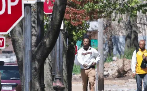 Two people walking through a neighborhood in St.Louis