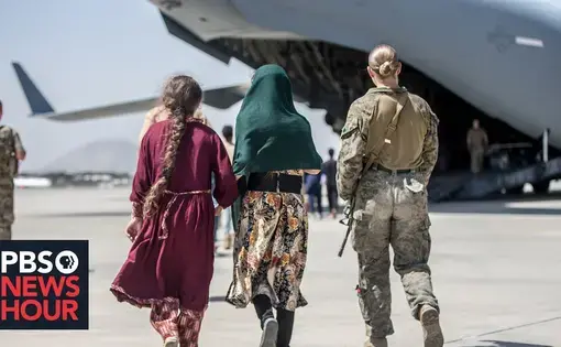 women and solider walk towards plane