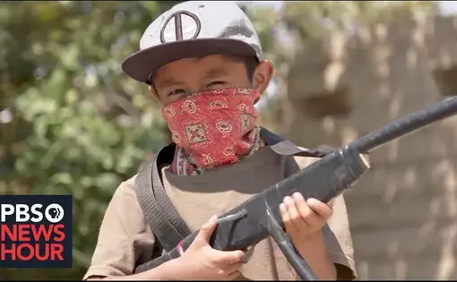 Young boy holds rifle