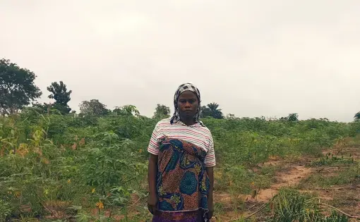 woman stands in front of farmland
