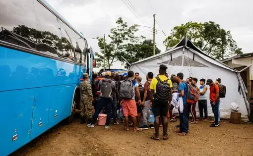 Migrants and refugees board bus