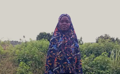 woman stands in front of farmland