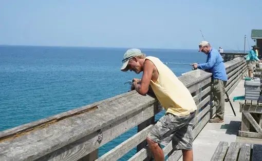 men look over fishing pier