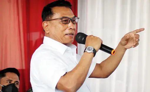 Presidential Staff Office Chief Moeldoko holding a microphone at a press conference